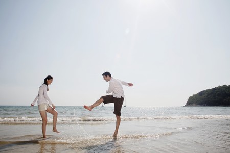Man and woman playing on beachの写真素材