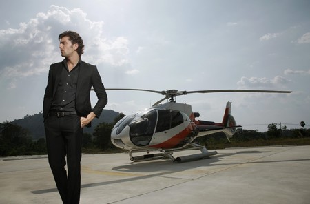 Businessman standing at helipad with helicopter in the backgroundの写真素材