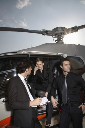 Business people discussing by the helicopterの写真素材