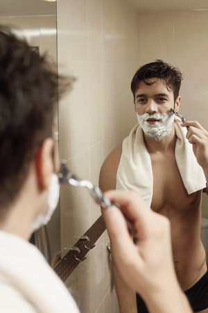 Man shaving in front of mirrorの写真素材