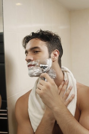 Man shaving in bathroomの写真素材