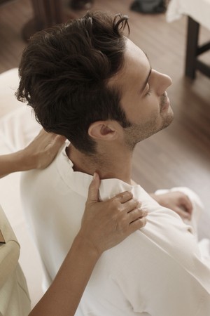 Massage therapist massaging man's shouldersの写真素材
