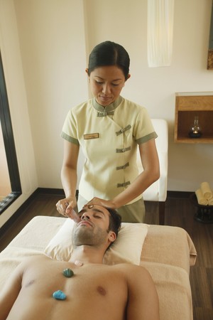 Man receiving crystal healing treatmentの写真素材