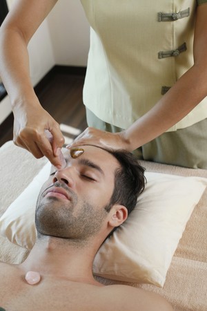 Man receiving crystal healing treatmentの写真素材