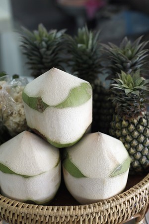 Coconuts and pineapples in basketの写真素材