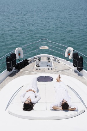 Couple sunbathing on yacht deckの写真素材