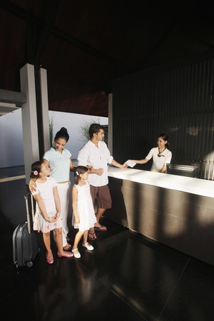 Family checking into resortの写真素材