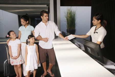 Family checking into resortの写真素材