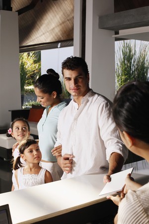 Family checking into resortの写真素材