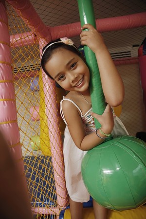 Girl posing with rope swing indoorsの写真素材