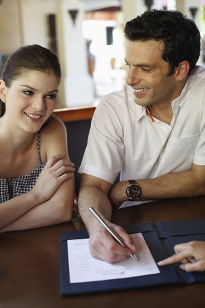 Man and woman checking into hotelの写真素材