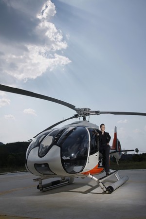 Businesswoman standing at the side of helicopterの写真素材