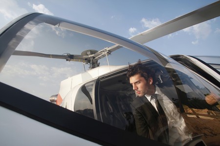Businessman stepping out of helicopterの写真素材