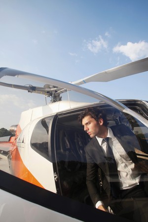 Businessman stepping out of helicopterの写真素材