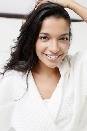 Woman in bathrobe sitting on the bedの写真素材