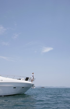 Couple standing at the tip of yachtの写真素材