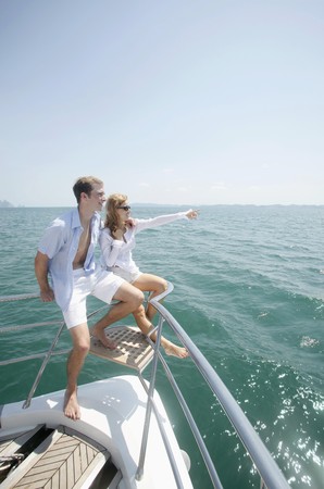 Couple relaxing at the tip of the yachtの写真素材