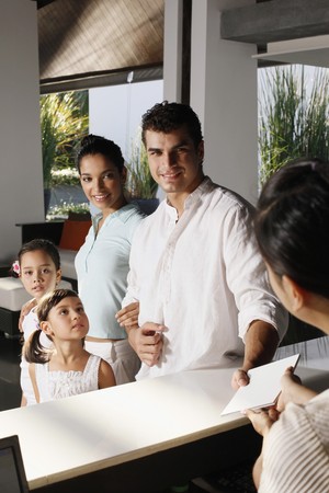 Family checking into resortの写真素材