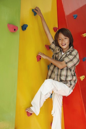 Boy climbing rock wallの写真素材