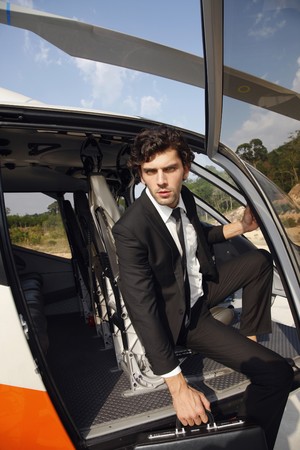 Businessman getting out from helicopterの写真素材