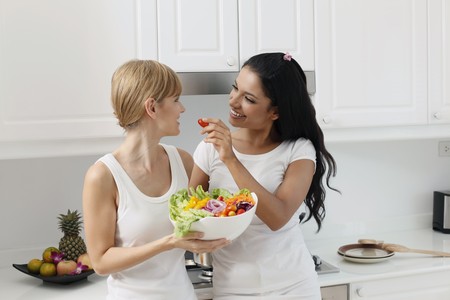 Women sharing a bowl of saladの写真素材