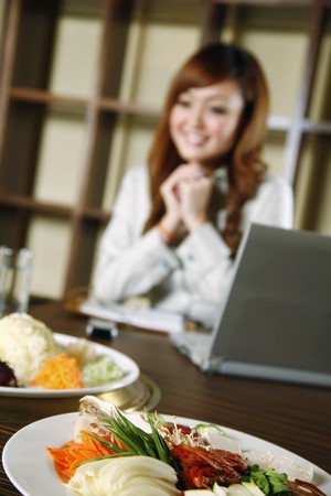 Businesswoman looking at japanese foodの写真素材