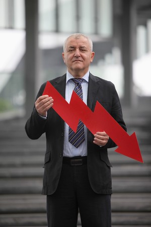 Businessman with a down pointing arrowの写真素材