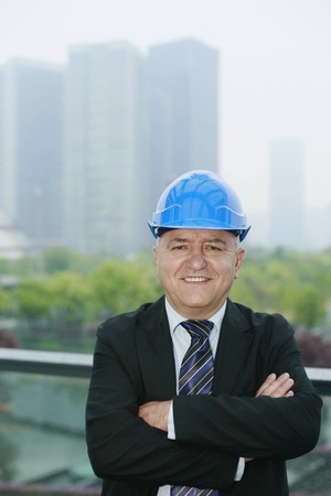 Businessman with hardhat crossing his arms
