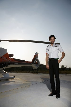Pilot standing beside a helicopterの写真素材
