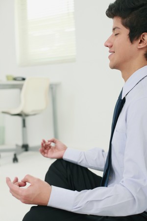 Businessman meditating in officeの写真素材