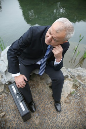 Businessman sitting on a rockの写真素材