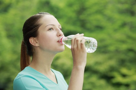 Woman drinking water from a plastic bottleの写真素材