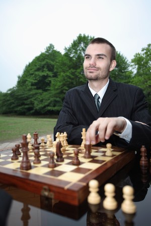 Businessmen playing chess outdoors