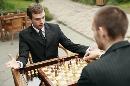 Businessmen playing chess outdoors