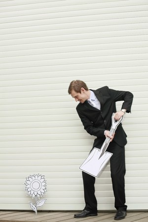 Businessman holding a shovelの写真素材