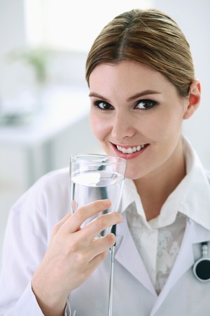 Doctor drinking a glass of waterの写真素材
