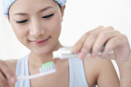 Woman squeezing toothpaste onto toothbrush