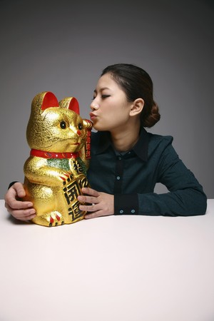 Woman kissing ceramic cat ornamentの写真素材