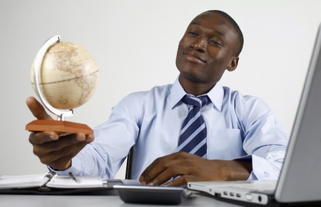 Businessman smiling while looking at globeの写真素材
