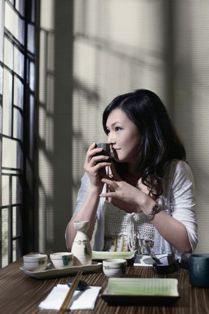 Woman sniffing a cup of teaの写真素材