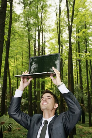 Businessman looking under a laptopの写真素材