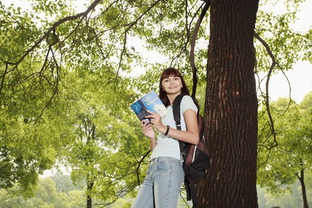 Woman reading book outdoorsの写真素材