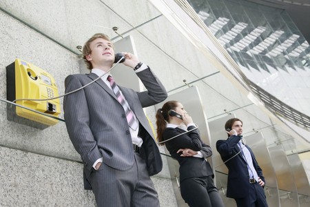 Business people using public telephonesの写真素材