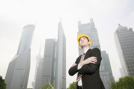 Businessman wearing safety hat with arms crossed
