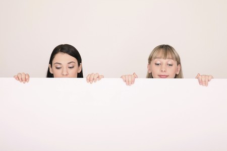 Women standing behind blank placardの写真素材