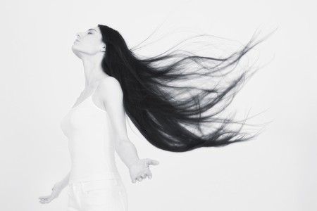 Woman with hair blowing in the windの写真素材