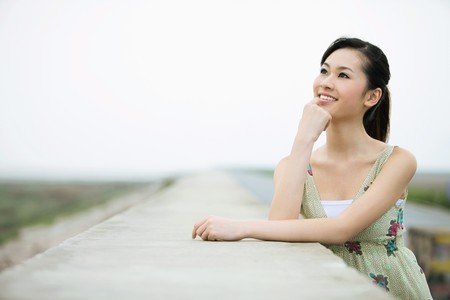 Woman day dreaming outdoorsの写真素材