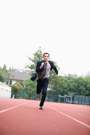 Businessman running on trackの写真素材