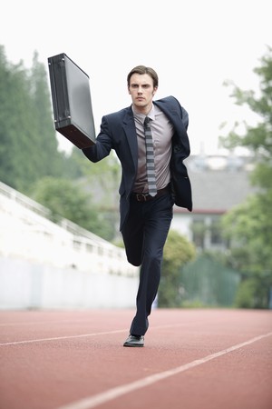 Businessman running on trackの写真素材