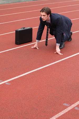Businessman crouching on running track